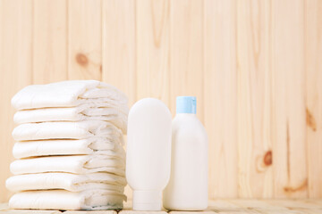 Baby diapers with toiletries on brown wooden background