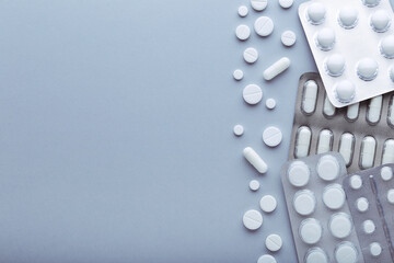 White pills in blisters on grey background