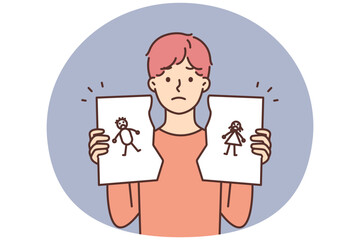 Unhappy child hold torn family picture