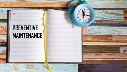 The concept of the preventive maintenance text, written in a notebook, next to the clock