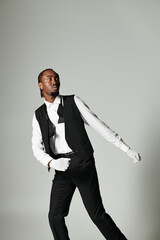 A well-dressed young man strikes a fashionable pose in a tailored suit and vest, showcasing...
