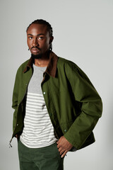 A young African American man showcases his fashion flair in a striking green outfit, exuding style and attitude.