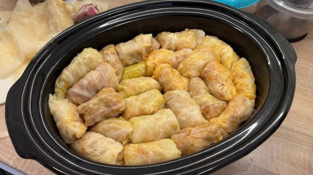 Sarma, a traditional Serbian food, prepared in a slow cooker. These stuffed cabbage rolls are filled with a savory mixture and wrapped in cabbage leaves, ready for slow cooking