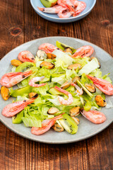 Seafood salad with shrimps and mussels on plate.