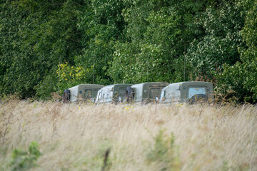 four Land Rover Wolf army vehicles amongst tall late summer grasses