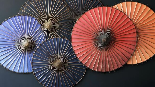 Five traditional Japanese parasols are displayed against a dark background