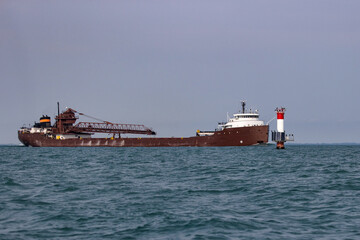 Great lakes freighter passing a channel marker