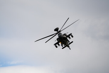 close-up of a British army Boeing Apache Attack helicopter gunship AH64E AH-64E ArmyAirCorp banking hard in low level overhead flight