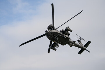 close-up of a British army Boeing Apache Attack helicopter gunship AH64E AH-64E ArmyAirCorp banking hard in low level overhead flight