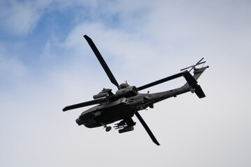 close-up of a British army Boeing Apache Attack helicopter gunship AH64E AH-64E ArmyAirCorp banking hard in low level overhead flight