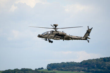 close-up side view of a British army Boeing Apache Attack helicopter gunship AH64E AH-64E ArmyAirCorp in low level flight