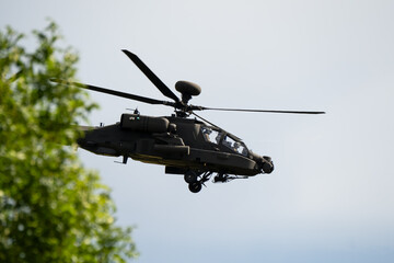 Fototapeta premium close-up side view of a British army Boeing Apache Attack helicopter gunship AH64E AH-64E ArmyAirCorp in low level flight