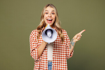 Young woman she wears red shirt white t-shirt casual clothes hold in hand megaphone scream announces discounts sale Hurry up point aside isolated on plain pastel green background. Lifestyle concept.