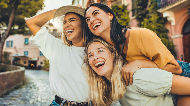 Fototapeta Three multiethnic girls having fun walking in city street - Happy young women laughing together enjoying summertime vacation