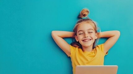 Young girl smiling, hands behind head, relaxing during a break, working on a laptop, isolated against a vibrant blue background, cheerful and positive mood.