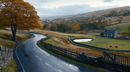 Fototapeta premium Rain falls heavily on a winding country road in England, bordered by vibrant grass and trees, creating a serene yet moody ambiance
