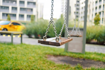 Close up of empty swing at playground. Modern children's playground in a residential building. High...