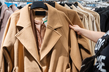 Customer Hand Picking Coat from Clothing Rack in Store