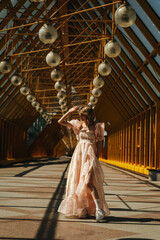An Elegant Woman Wearing a Flowing Dress Poses Beautifully Under an Architectural Structure