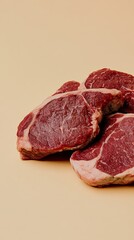 Fototapeta premium Fresh meat ready to cook on a beige background, perfect for a gourmet meal. High in protein and fat, these beef steaks are nutritious and delicious. Ideal for grilling or a barbecue