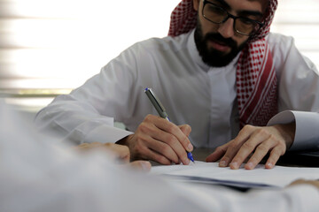 Saudi man Signs documents in workplace