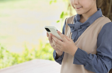 Primary school girl, female child using smartphone safely, concept of safe mode, kid friendly internet connection, hand closeup shot