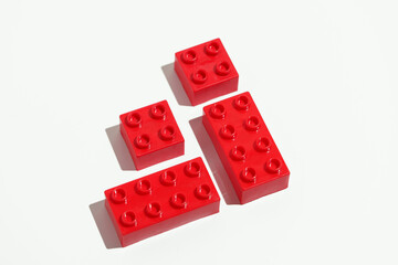 Top view of red plastic blocks bricks toy for building constructions on white isolated background....