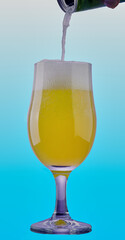 Cold drink being pored in to glass with a vibrant background.