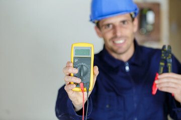 a happy electrician showing multimeter