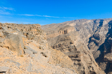 Exploring the rugged mountains of Oman under a clear blue sky in a remote desert landscape