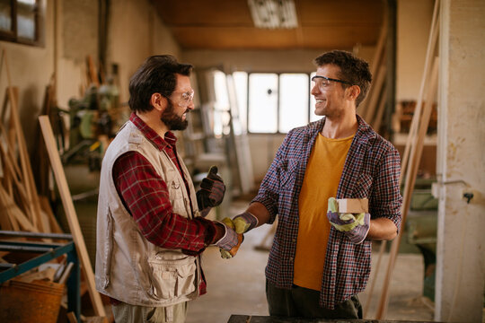 Carpenters having a handshake in the woodworking workshop
