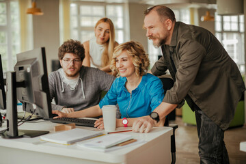 Fototapeta premium Young people using a computer while working in a startup company office