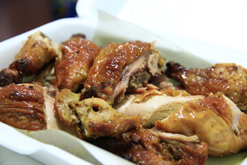 Grilled chicken cut into pieces ready to eat in a foam box.