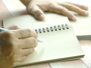 Hand writing in notebook on brown background. Insurance or financial business concept.