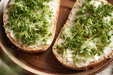 Fresh garden cress sprouts on slices of sourdough bread, closeup