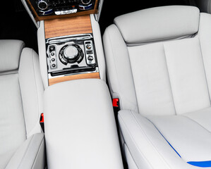 Modern luxury car white leather interior with natural wood panel. Part of leather car seat details...