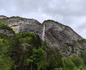 Arpenaz waterfall, one of France highest cascade in Haute Savoie in springtime with impressif cliff of Giffre Massif mountain, alpine landscape