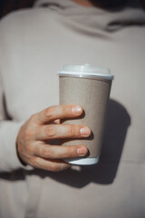 Handsome young man with a beard drinks delicious morning coffee from a paper cup, runs in the morning, wearing a tracksuit, sunglasses, hipster portrait,  workout, sunglasses, autumn, Paris