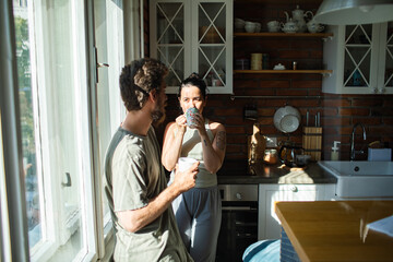 Couple talking in the kitchen at morning with coffee