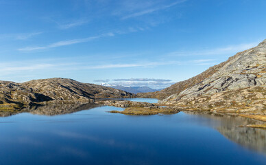 Beautiful mountain reflections in the lake surface in Northern Norway autumn. Seasonal scenery of Scandinavia.
