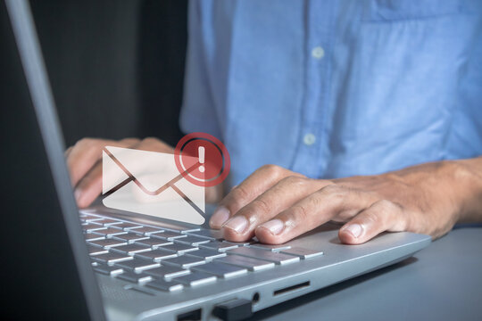 Man working on laptop with email spam notification alert with warning caution