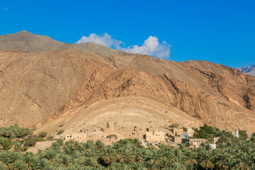 Exploring a tranquil oasis in Oman amidst the majestic mountains and lush palm groves