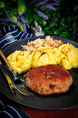 Minced meat cutlet served with mashed potatoes and salad.