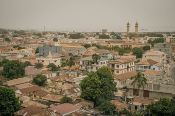 Obraz premium The scenic panorama view of Banjul city, a capital of Gambia, with mosque minaret, sea coast and roofs of African buildings. 