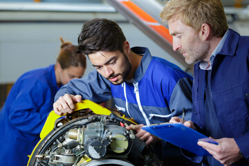 airplane service team repairing plane in hangar