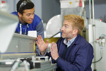 foreman using hands to show trainee the width needed