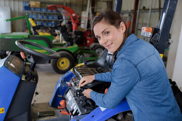 female mechanic carrying out maintenance on professional mower
