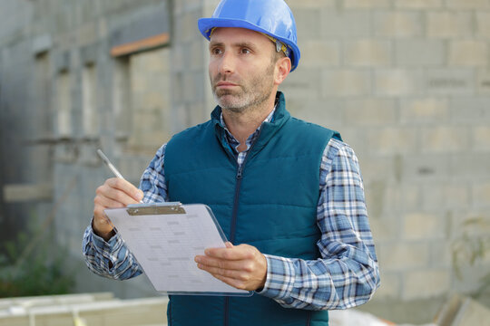 handy man with clipboard outdoors