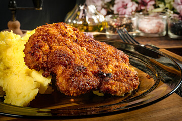 Breaded pork neck cutlet served with potatoes and salad.