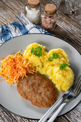 Minced meat cutlet served with mashed potatoes and carrot salad.